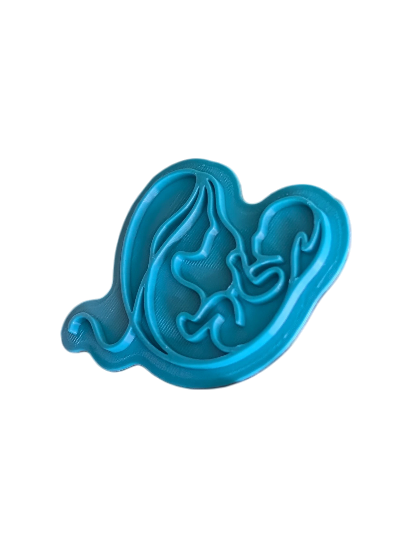 Detailansicht des türkisfarbenen Keramikstempels mit Mutter-Kind-Motiv. Die feinen Linien sind optimal für saubere, rissfreie Konturen beim Töpfern ausgeformt.