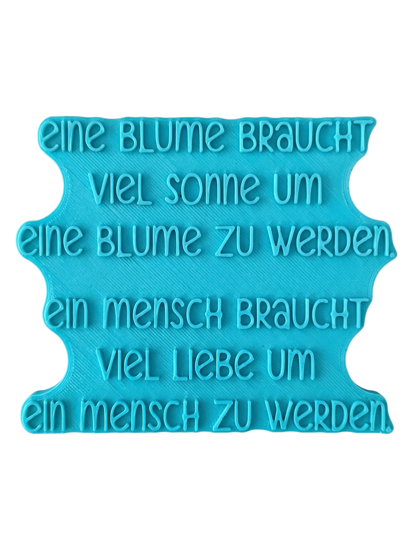 Blaugrüner Textstempel für Ton mit dem Spruch 'Eine Blume braucht viel Sonne...'. Stabiles Werkzeug für saubere, tiefe Prägungen in Keramik.