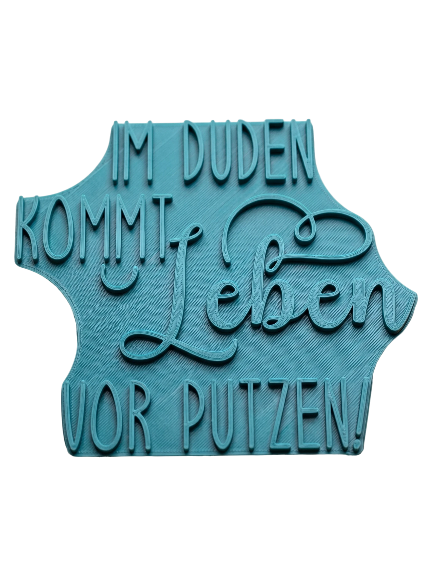 Türkisfarbener Keramikstempel für Ton mit dem lustigen Spruch 'Im Duden kommt Leben vor Putzen'. Hochwertiges Töpferzubehör für präzise Textprägungen.