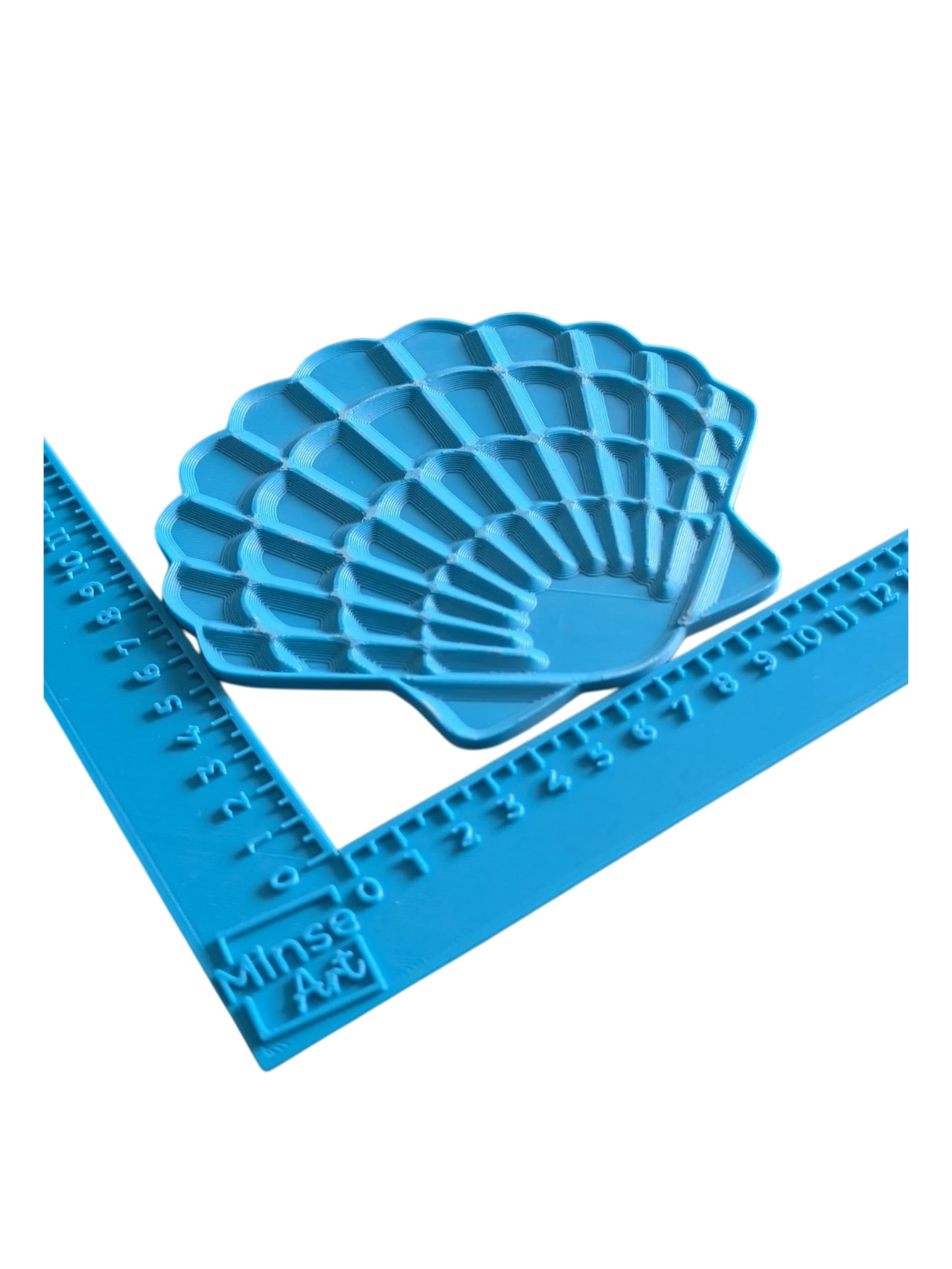 Perspektivische Ansicht des blauen Muschel-Stempels von MinseArt im blauen Winkel-Messinstrument (in cm), auf weißem Hintergrund zur Verdeutlichung der Tiefe und Größe.