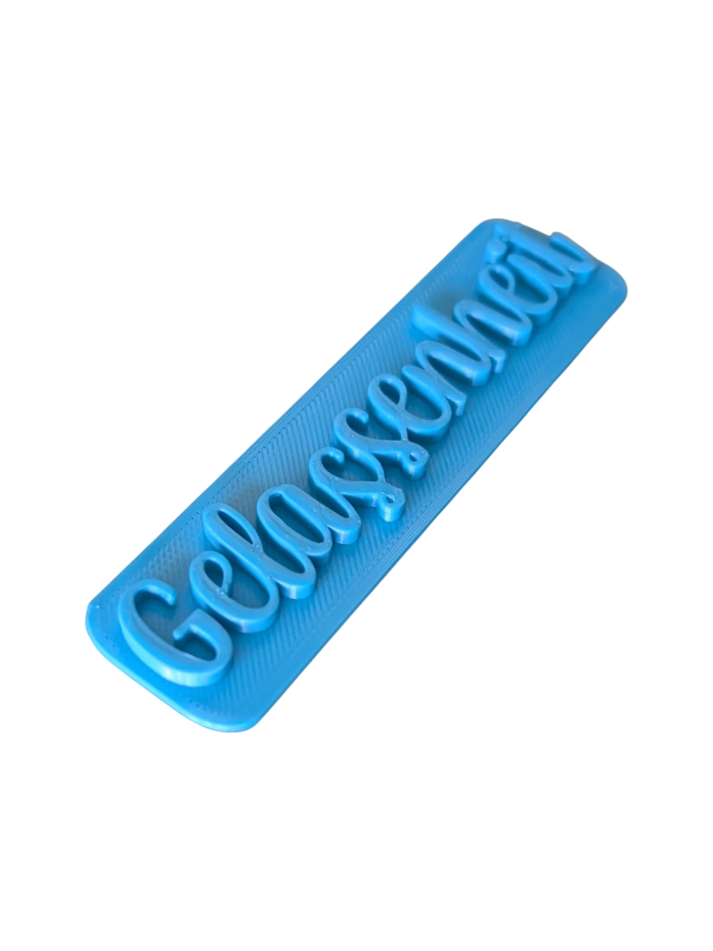 Perspektivische Detailansicht des blauen Stempels mit dem Schriftzug Gelassenheit für Töpferarbeiten.