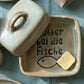 Handgemachte Keramik-Butterdose in Blaugrün und Hellbraun glasiert. Im Boden ist der Spruch 'Butter bei die Fische' mit einem Fisch tief eingestempelt. Eine kreative Töpfer-Idee.