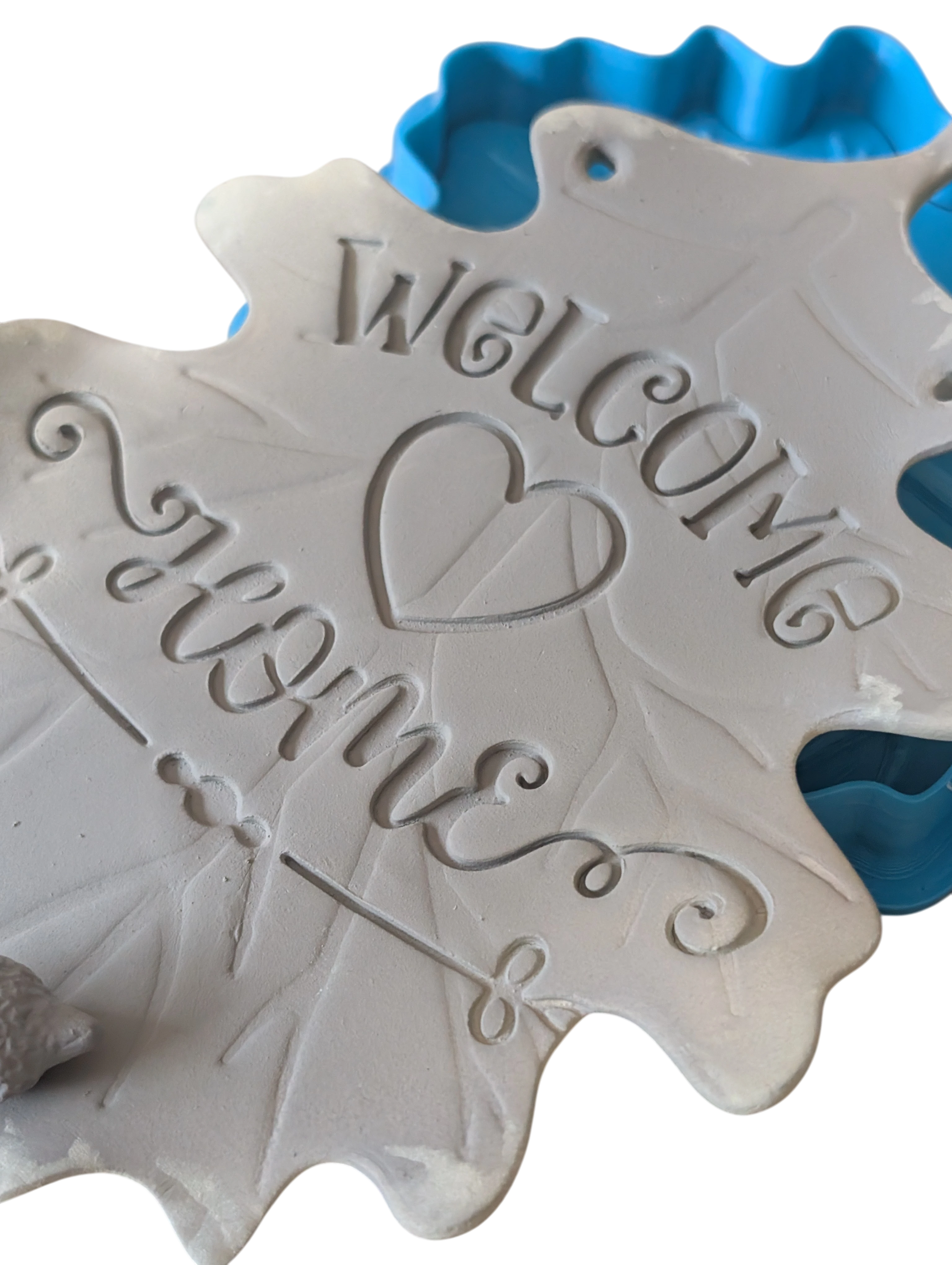 Präziser Stempelabdruck 'Welcome Home' in Eichenblatt-Form. Der Prägestempel sorgt für tiefe, saubere Konturen im Ton.