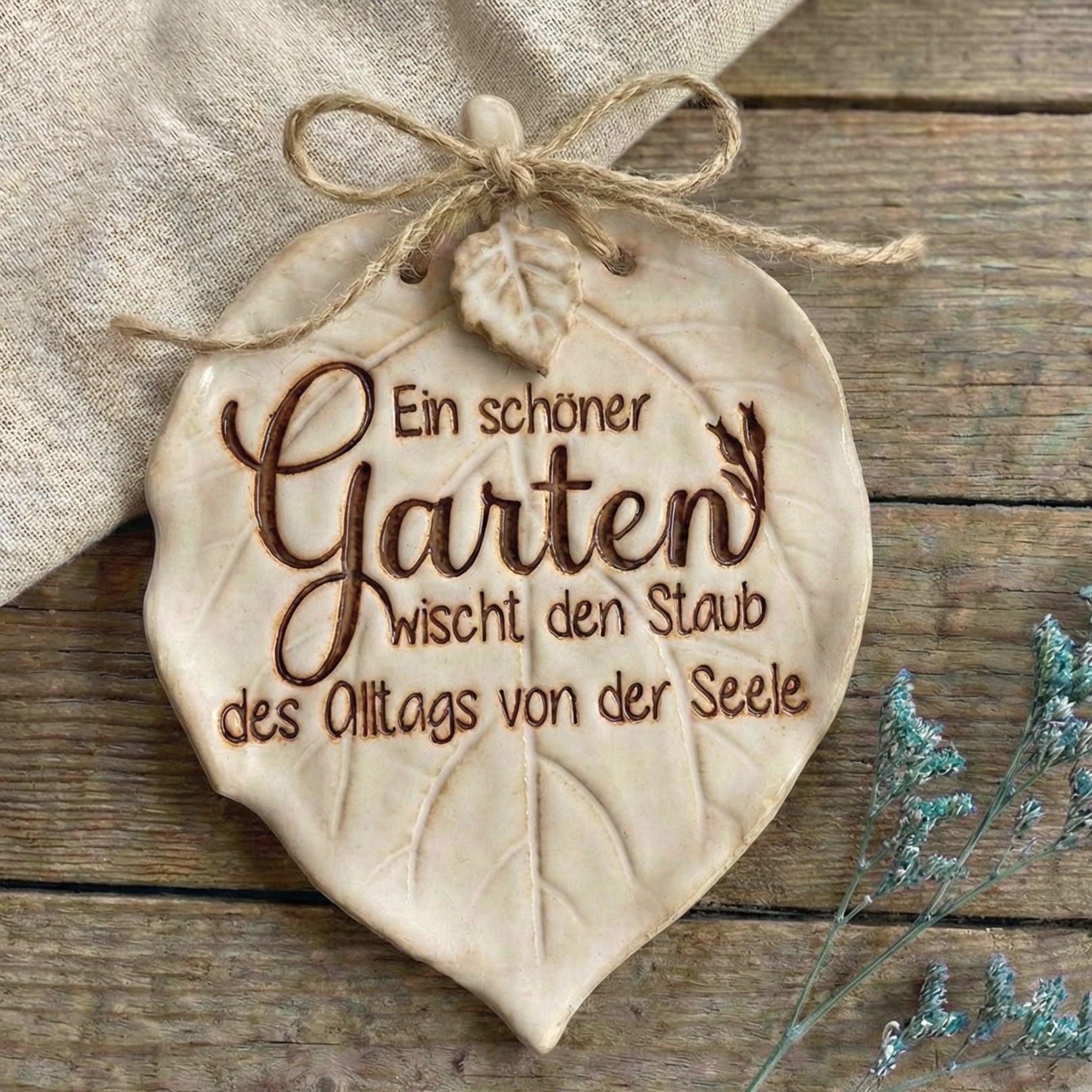 Handgefertigtes, glasiertes Keramikschild mit tiefem Stempelabdruck eines Gartenspruchs, dekoriert auf rustikalem Holz. Ein wunderschönes Projekt für echte Töpfer-Fans.