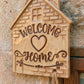 Glasiertes Keramikschild in Hausform mit eingestempeltem 'Welcome Home' Spruch. Eine kreative Töpfer-Idee für den Eingangsbereich.