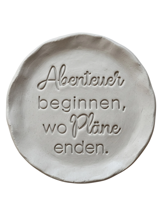 Sauberer Stempelabdruck des Spruchs 'Glücklich steht dir gut' in hellem Ton. Die Kombination aus eleganter Schreibschrift und klarer Druckschrift erzeugt ein präzises Relief