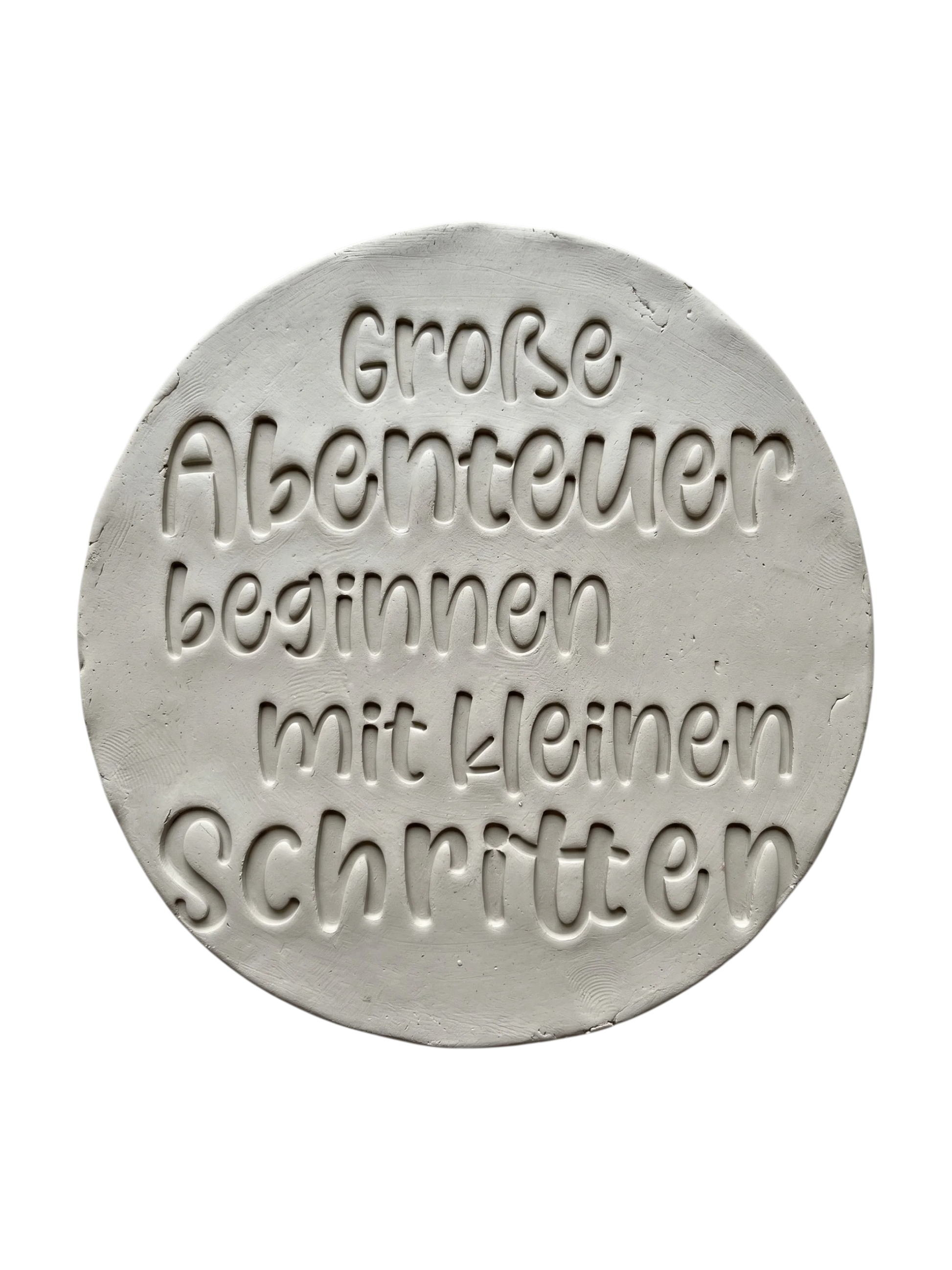 Detailreicher Abdruck im Ton mit dem Spruch 'Große Abenteuer beginnen mit kleinen Schritten'. Erstellt mit einem MinseArt Keramikstempel. Saubere Schriftzüge und präzise Konturen für deine nächste Töpfer-Idee im Bereich Baby-Geschenke und Kinderzimmer-Deko.