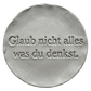 Präziser Stempelabdruck 'Glaub nicht alles was du denkst' in hellem Ton. Sauberes, tiefes Relief auf einer runden Tonplatte, erstellt mit einem MinseArt Textstempel.