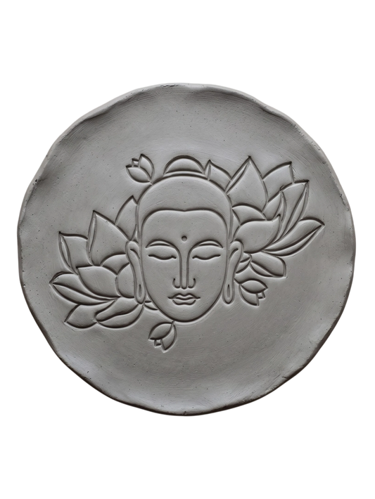 Präziser Stempelabdruck eines Buddhas mit Blumen auf einer runden Tonplatte. Inspiration für meditative Wandbilder oder dekorative Schalen aus Keramik.
