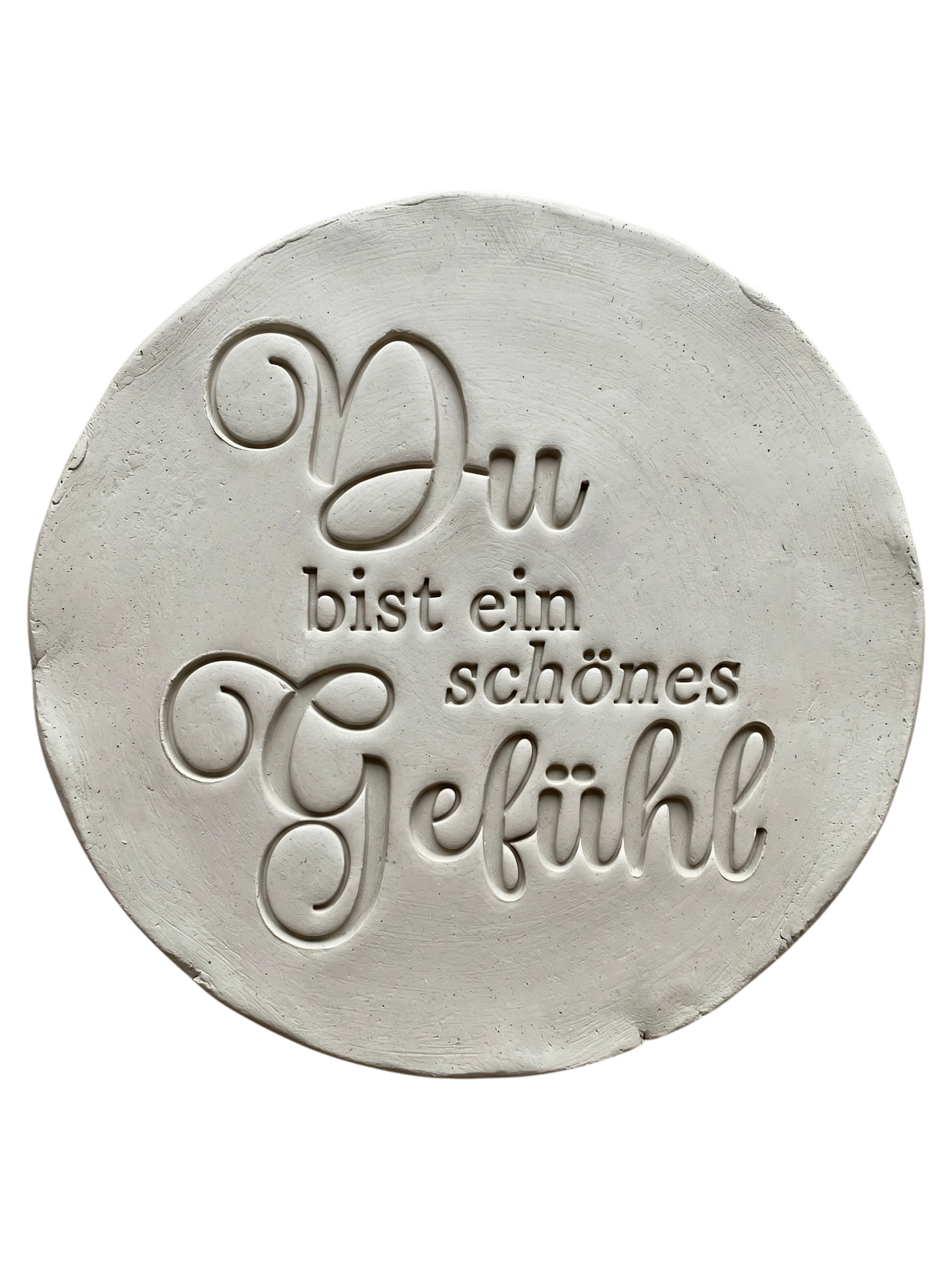 Präziser Stempelabdruck des Spruchs 'Du bist ein schönes Gefühl' in hellem Ton. Die elegante Kombination aus schwungvoller Schreibschrift und klassischer Serifenschrift erzeugt ein tiefes Relief auf der runden Tonplatte.