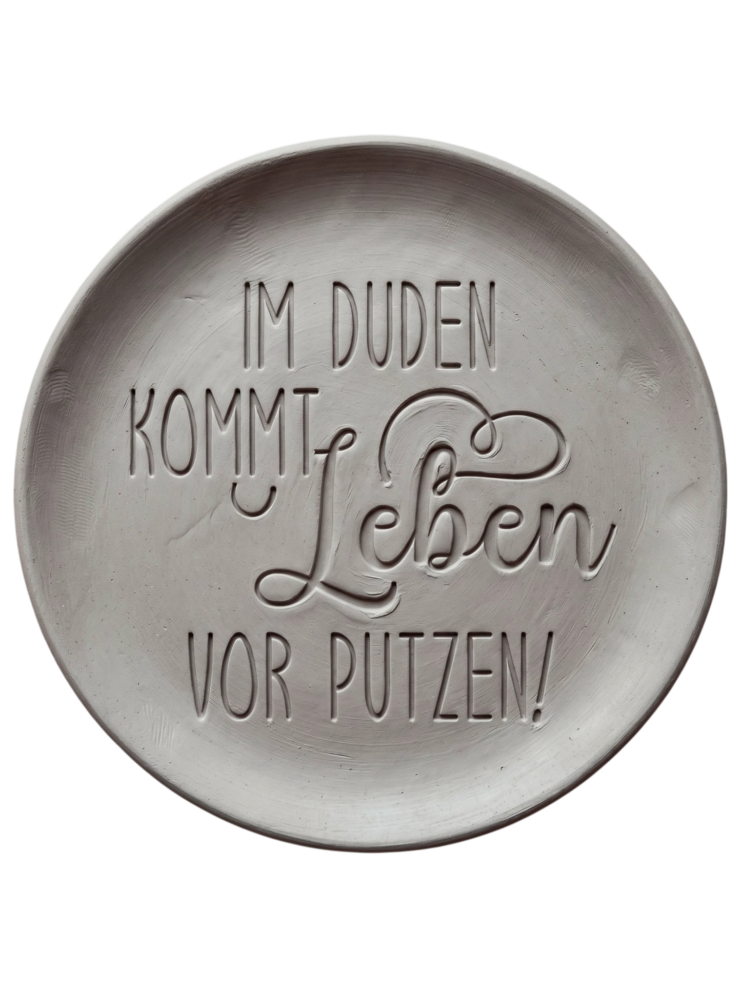 Witziger Stempelabdruck 'Im Duden kommt Leben vor Putzen' in hellem Ton. Sauberes Relief mit einer Kombination aus moderner Druckschrift und schwungvoller Schreibschrift.