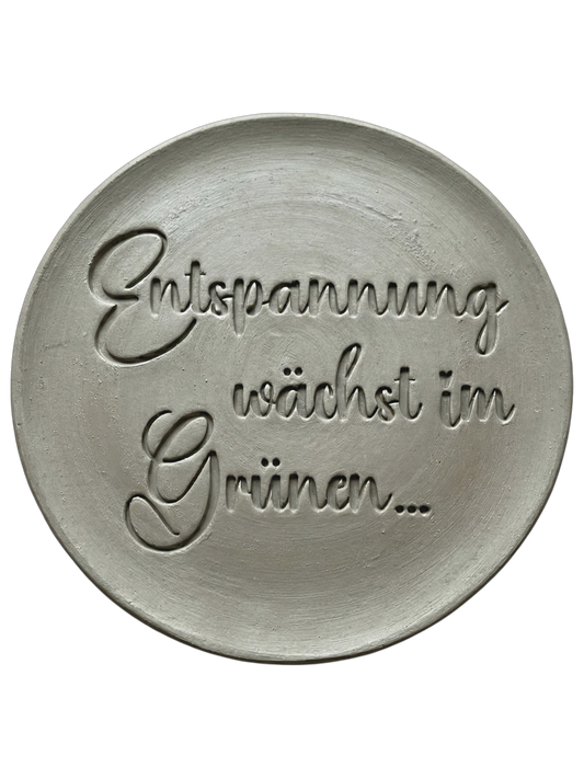 Präziser Abdruck des Spruchs 'Entspannung wächst im Grünen...' in hellem Ton. Filigranes Schrift-Relief für Gartenkeramik und Wellness-Geschenke.