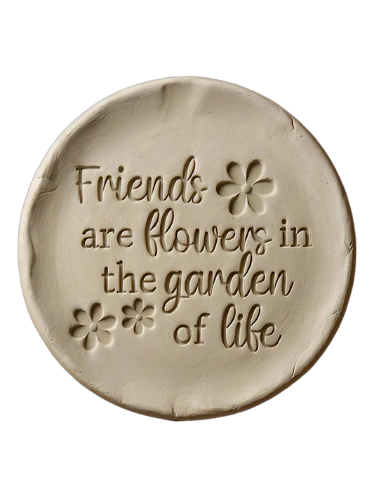 Detailreicher Abdruck im hellen Ton mit dem Spruch 'Friends are flowers in the garden of life' und geprägten Blumen. Kreative Töpfer-Idee für Freundschaftsgeschenke oder Dekoration