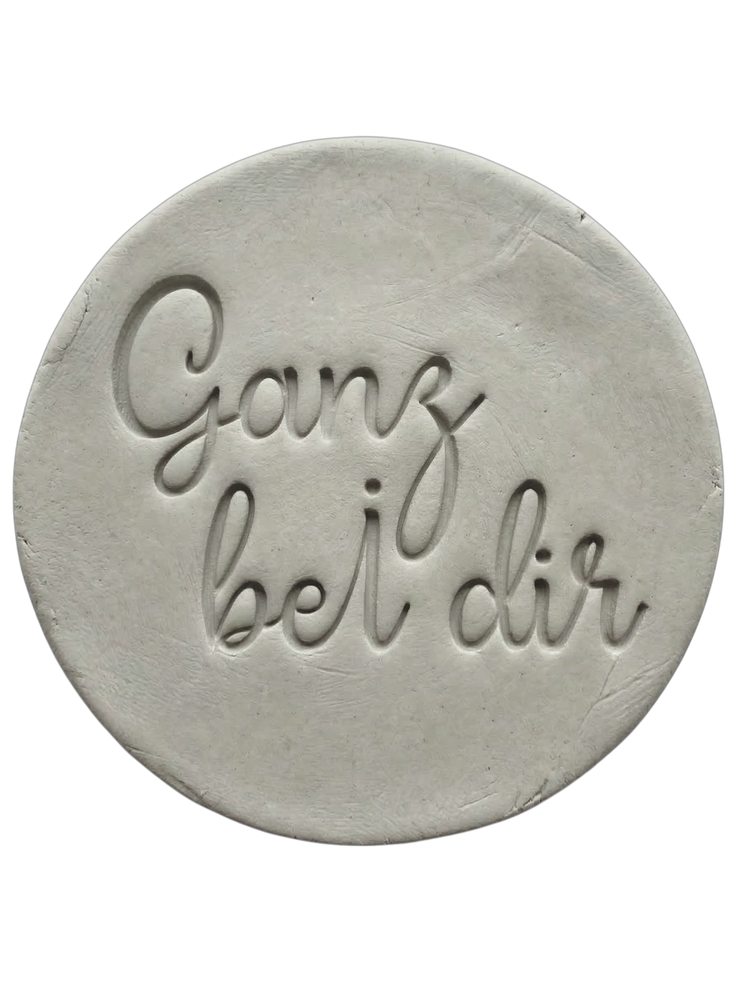 Filigraner Stempelabdruck in eleganter Handschrift mit dem Spruch 'Ganz bei dir' auf einer runden Tonplatte. Sauberes Relief-Ergebnis für meditative Keramik, gestaltet mit einem MinseArt Keramikstempel.