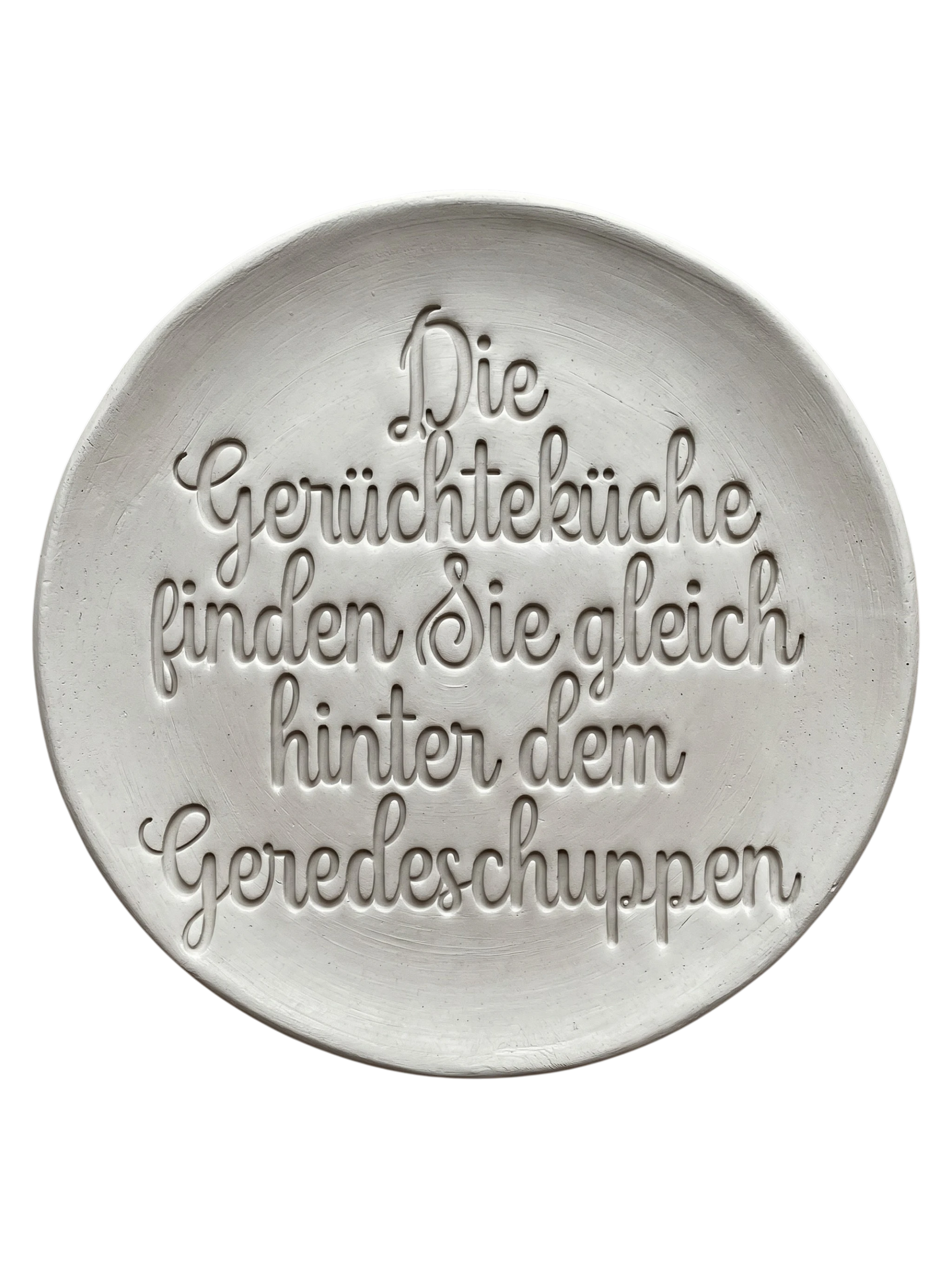 Präziser Stempelabdruck des Spruchs 'Die Gerüchteküche finden Sie gleich hinter dem Geredeschuppen' in hellem Ton. Sauberes Relief in eleganter Schreibschrift, erstellt mit einem MinseArt Keramikstempel.