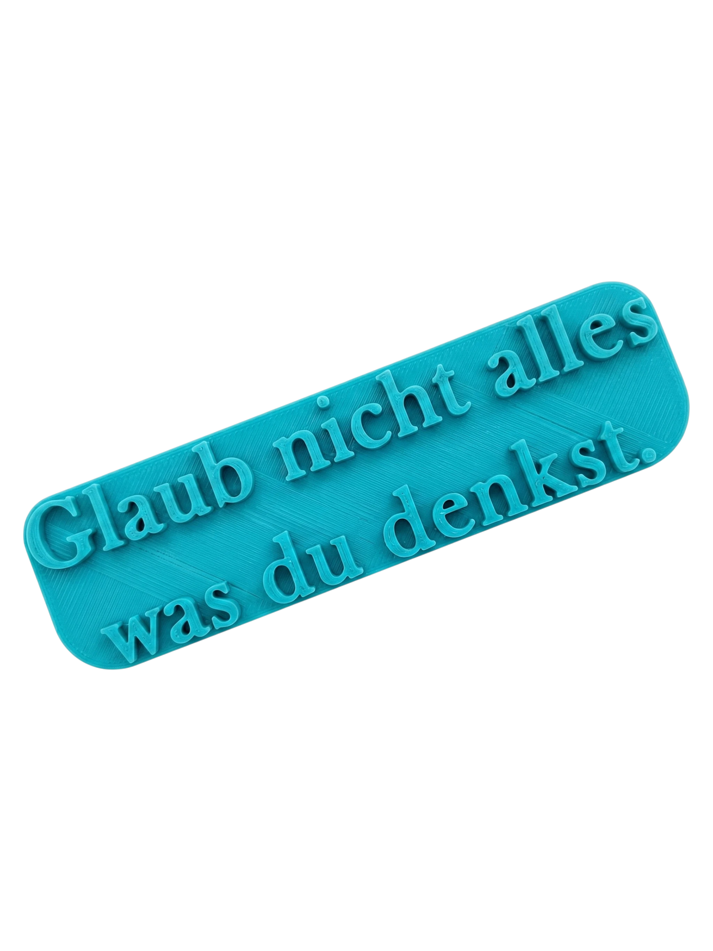 Türkisfarbener Keramikstempel mit dem Schriftzug 'Glaub nicht alles was du denkst' in eleganter Serifenschrift. Hochwertiges Prägewerkzeug von MinseArt für Ton.