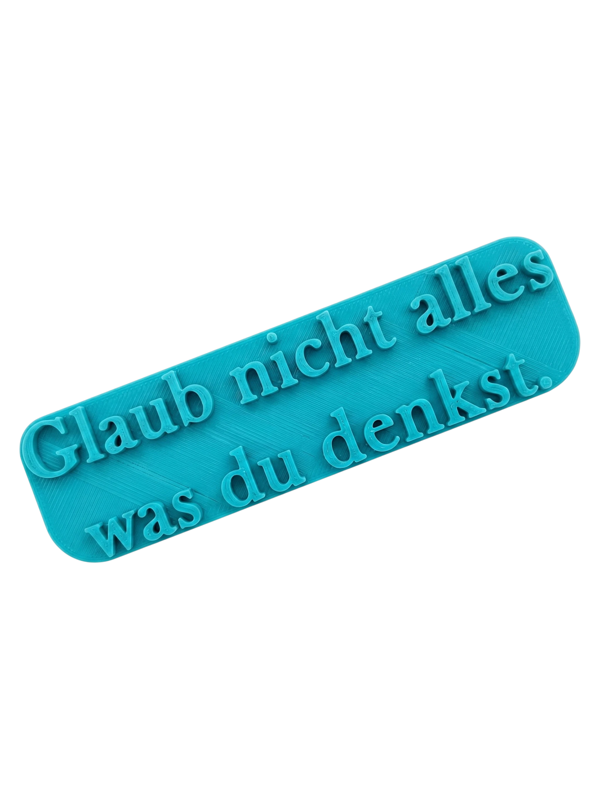Türkisfarbener Keramikstempel mit dem Schriftzug 'Glaub nicht alles was du denkst' in eleganter Serifenschrift. Hochwertiges Prägewerkzeug von MinseArt für Ton.