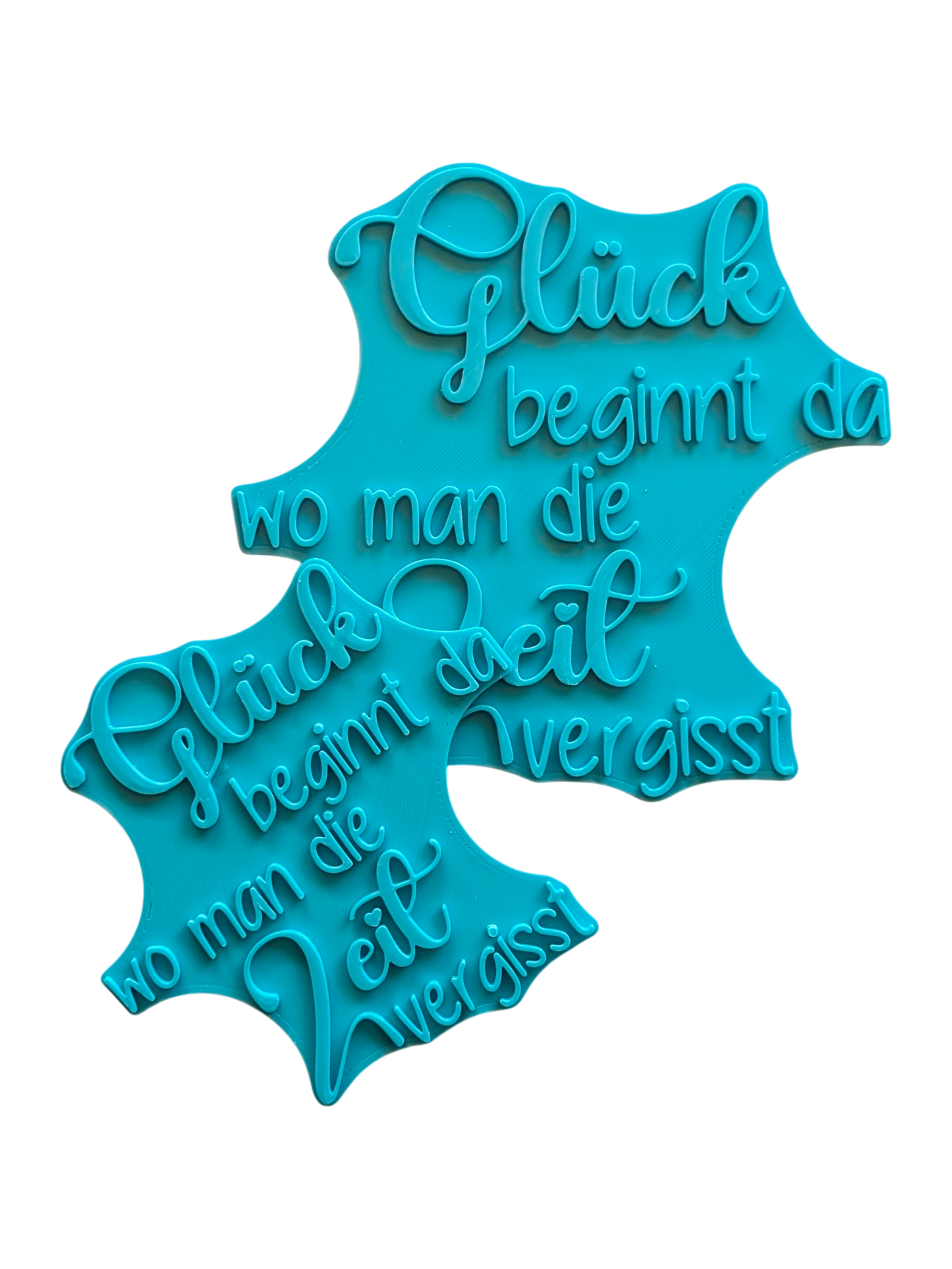 Zwei türkisfarbene Keramikstempel in verschiedenen Größen mit dem schönen Spruch 'Glück beginnt da wo man die Zeit vergisst'. Detailreicher Textstempel für handgemachte Töpfer-Ideen.