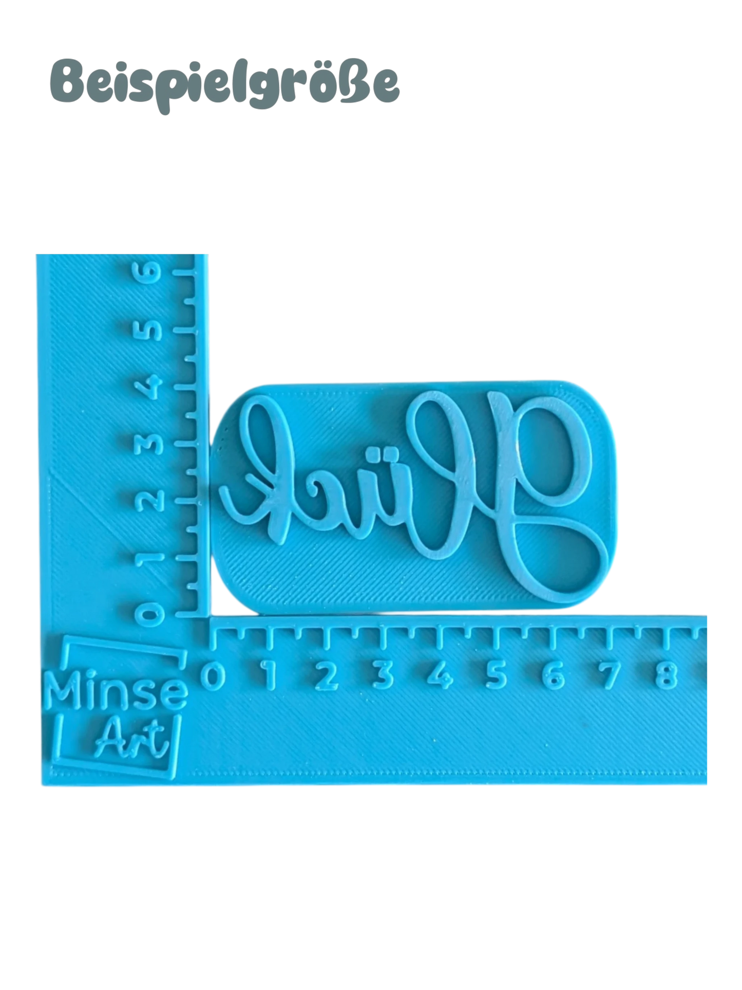 Blauer Keramikstempel mit dem Schriftzug Glück im blauen Winkel-Messinstrument (in cm) zur genauen Längenbestimmung.