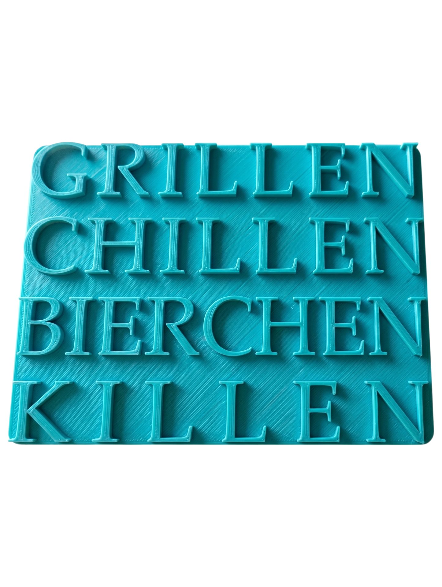 Türkisfarbener Keramikstempel für Ton mit dem lustigen Schriftzug 'Grillen Chillen Bierchen Killen'. Hochwertiges Töpferwerkzeug mit klaren Druckbuchstaben für witzige Keramikprojekte.