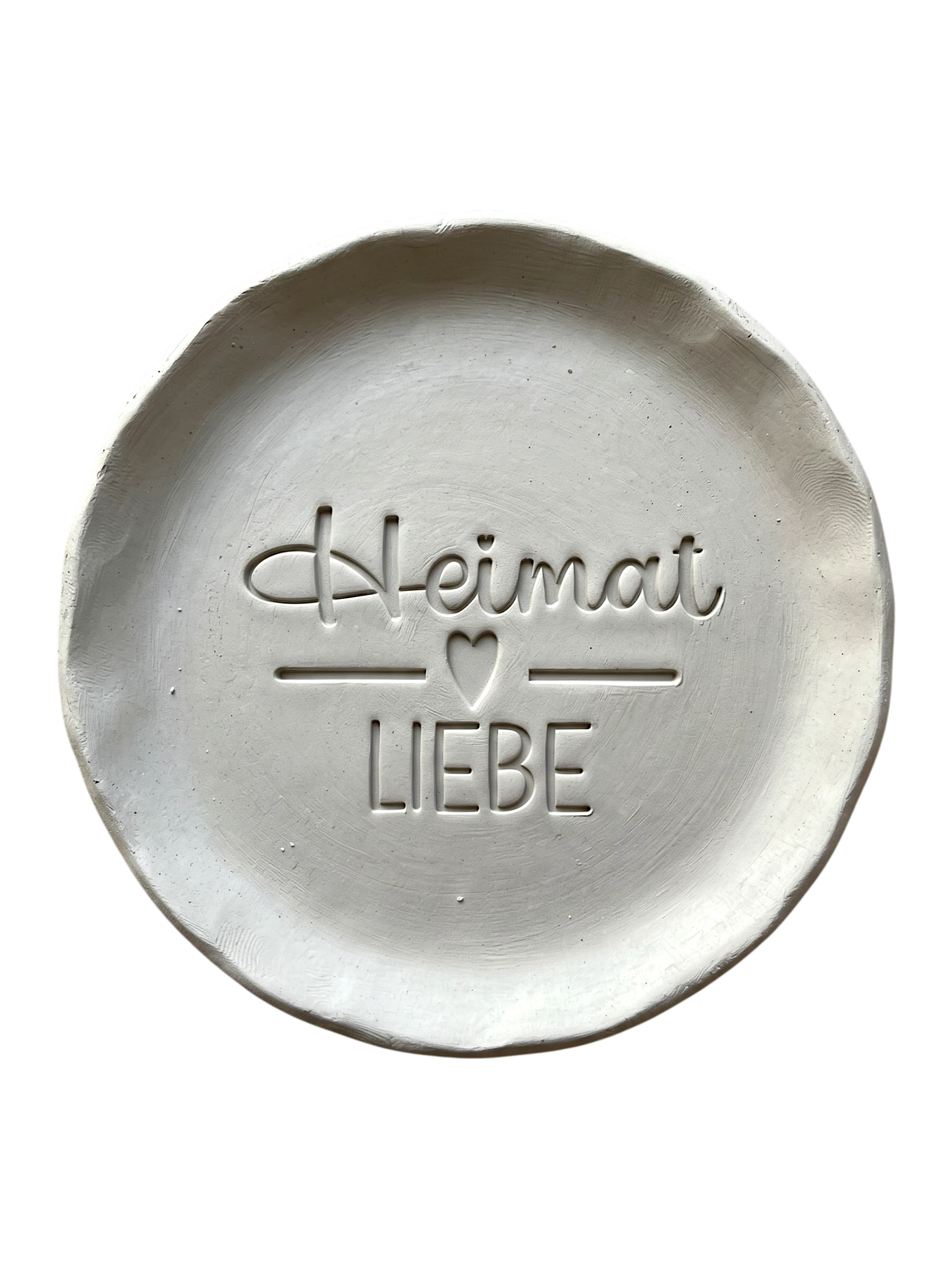 Sauberer Abdruck im hellen Ton mit dem Spruch 'Heimat Liebe'. Kreative Töpfer-Idee für regionale Wandteller, Türschilder oder rustikale Deko.
