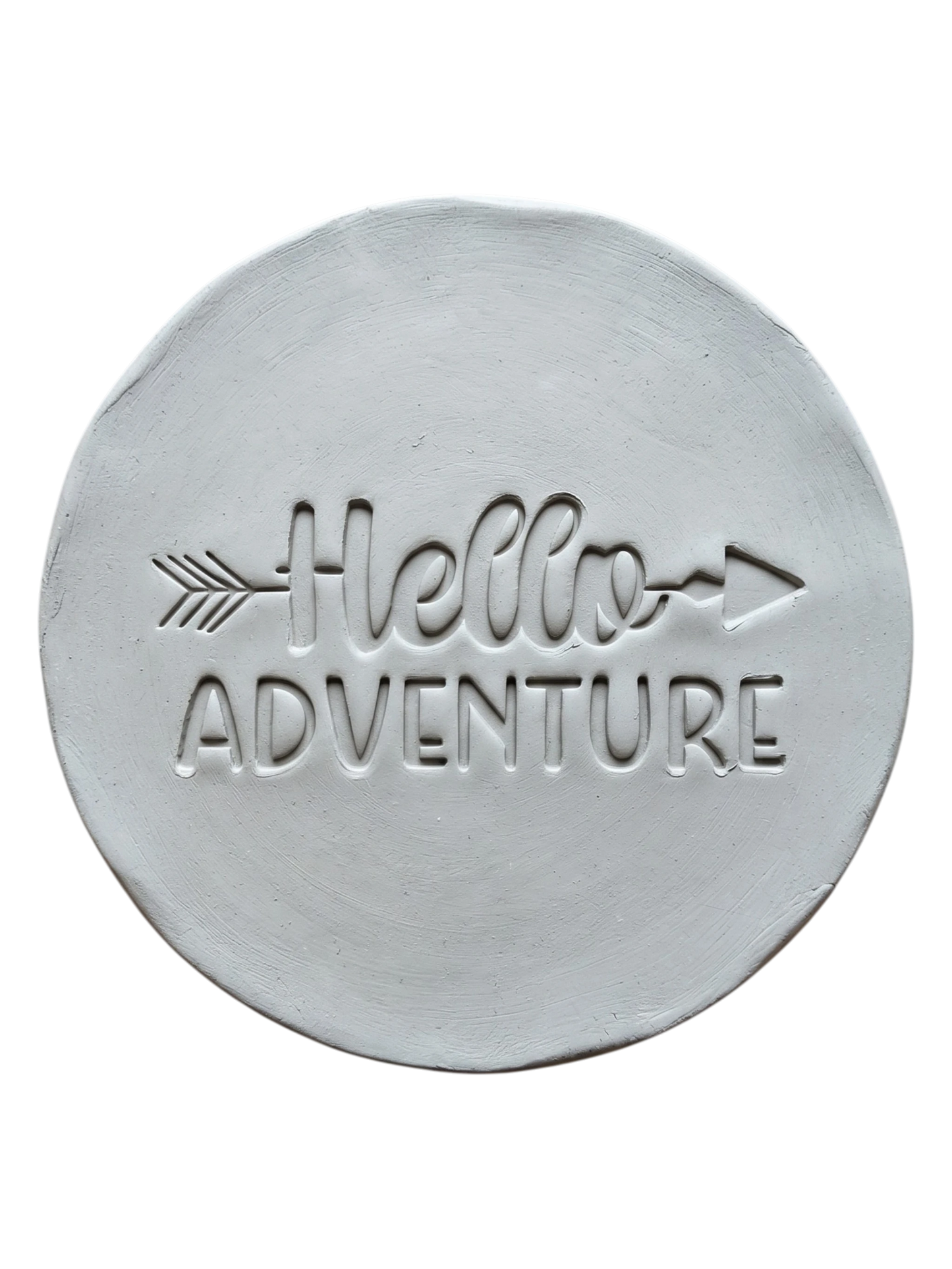 Präziser Abdruck im hellen Ton mit dem Spruch 'Hello Adventure'. Eine kreative Töpfer-Idee für Reisetagebücher aus Ton, Wandteller oder Geschenke zum Abenteuer-Start.