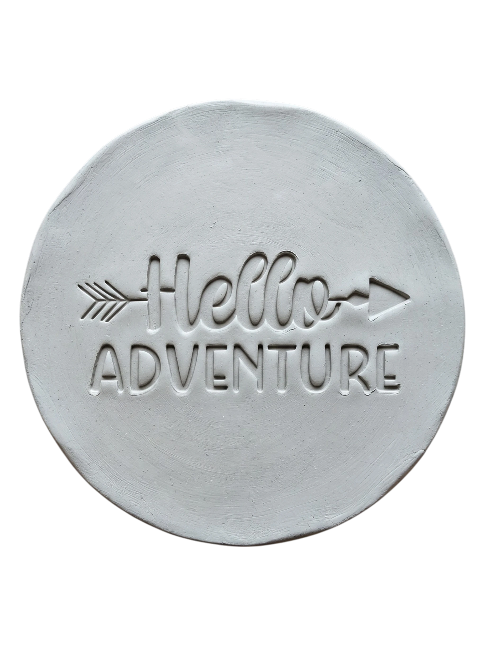 Präziser Abdruck im hellen Ton mit dem Spruch 'Hello Adventure'. Eine kreative Töpfer-Idee für Reisetagebücher aus Ton, Wandteller oder Geschenke zum Abenteuer-Start.