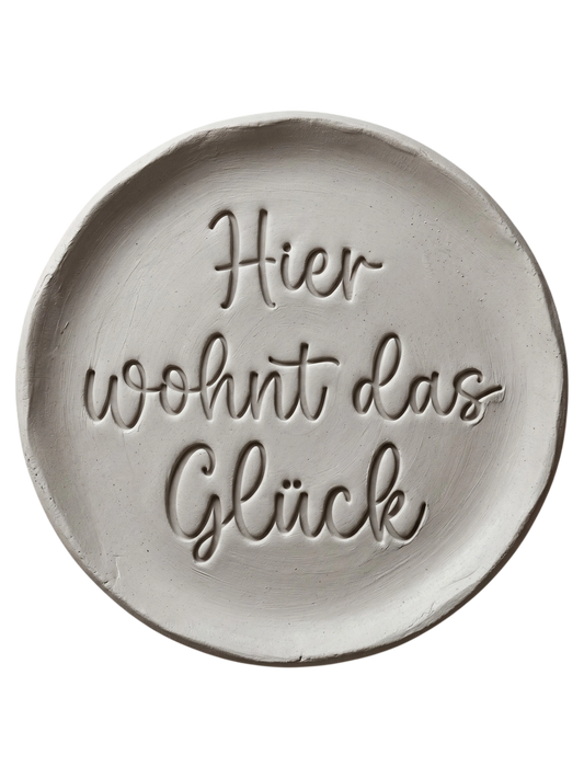 Türkisfarbener Keramikstempel für Ton mit der Aufschrift 'Hier wohnt das Glück' in eleganter Schreibschrift. Hochwertiges Töpferwerkzeug von MinseArt für saubere Textprägungen.