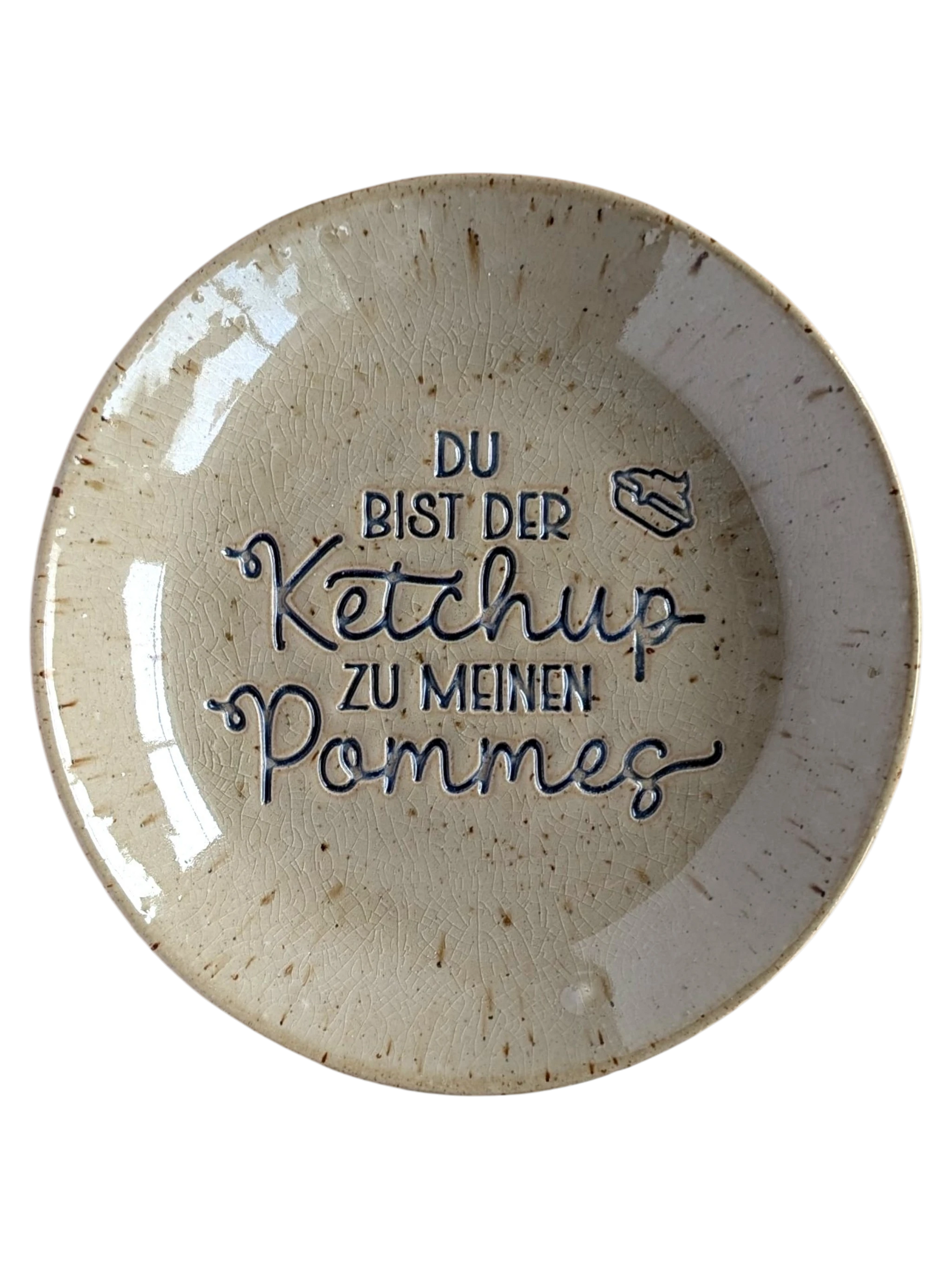 Ein glasierter Keramikteller mit dem handgemachten Stempelabdruck 'Du bist der Ketchup zu meinen Pommes'. Detailreicher Schriftzug und eine kleine Pommesschachtel als Verzierung für kreative Töpferprojekte.