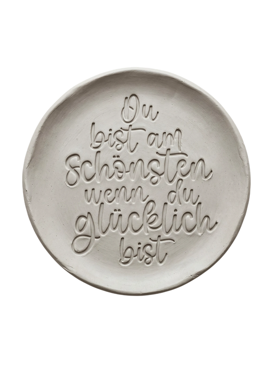 Präziser Stempelabdruck eines herzlichen Kompliments in hellem Ton. Die durchgehend schwungvolle Handschrift erzeugt ein sauberes, tiefes Relief auf der runden Tonplatte.