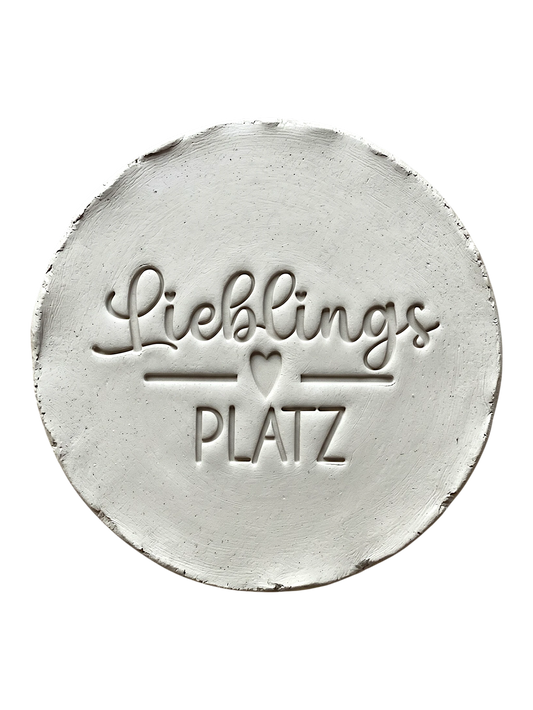 Präziser Abdruck im hellen Ton mit dem Schriftzug 'Lieblingsplatz' und Herz-Detail. Kreative Töpfer-Idee für Türschilder, Garten-Deko oder Wandteller.