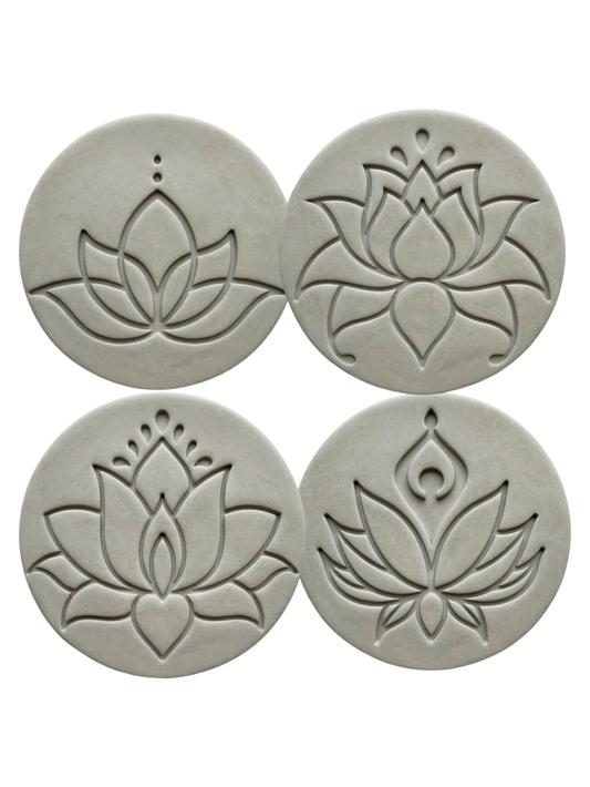 vier präzise Stempelabdrücke im Set moderner Lotusblüten in runden, hellgrauen Tonplatten. Das minimalistische Design mit klaren Linien und zwei Punkten über der Blüte zeigt die tiefe Relief-Wirkung der MinseArt Keramikstempel.