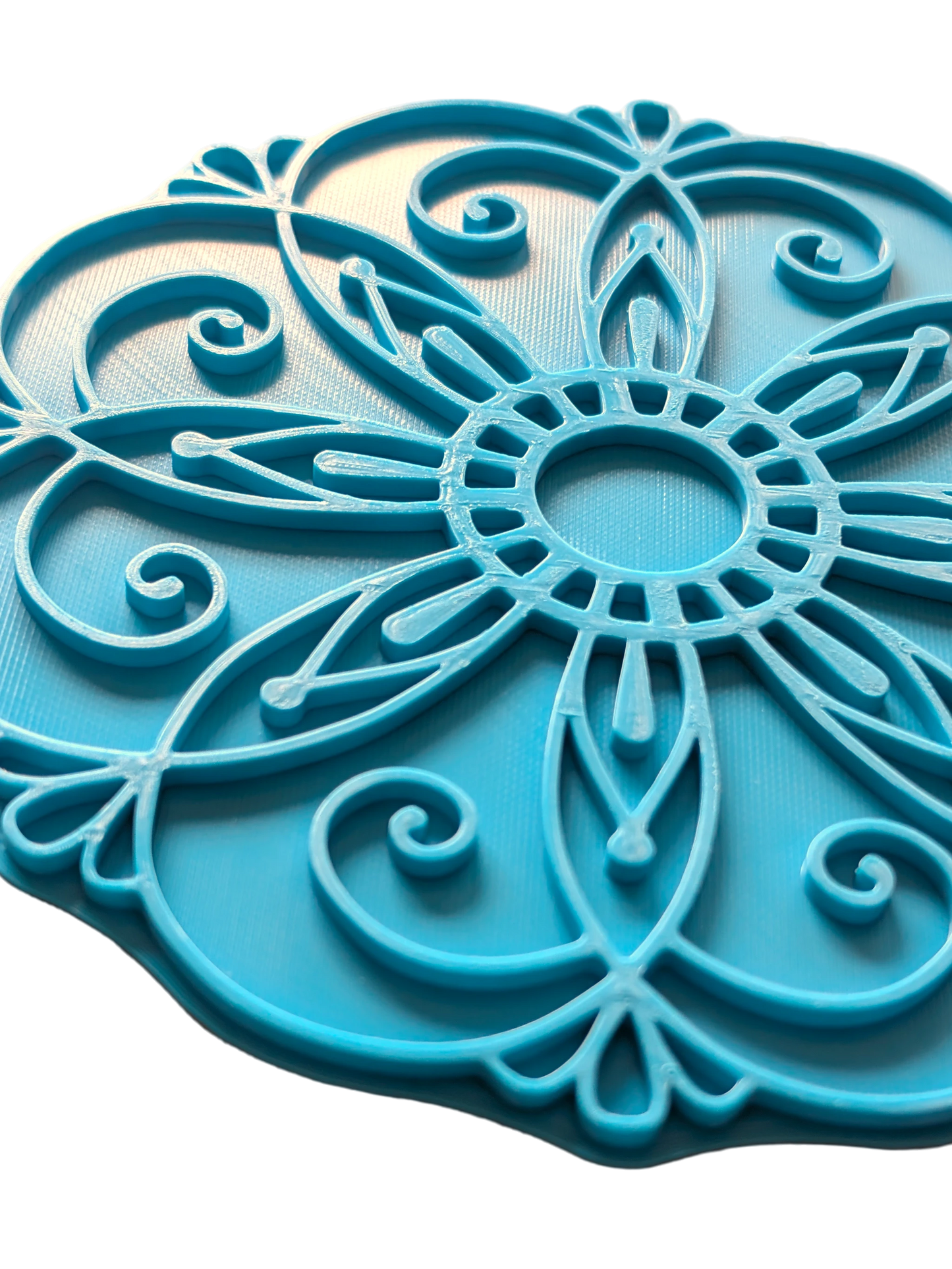 Nahaufnahme des türkisfarbenen Keramikstempels mit floralem Mandala-Muster. Der detailreiche Prägestempel zeigt feine Linien und Bögen für perfekte Abdrücke im Ton.