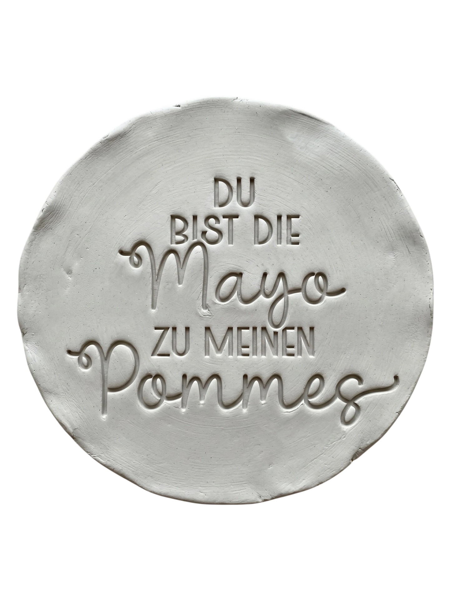 Präziser Stempelabdruck des humorvollen Spruchs 'Du bist die Mayo zu meinen Pommes' in hellem Ton. Detailreiches und sauberes Relief auf einer runden Tonplatte für handgemachte Keramik.