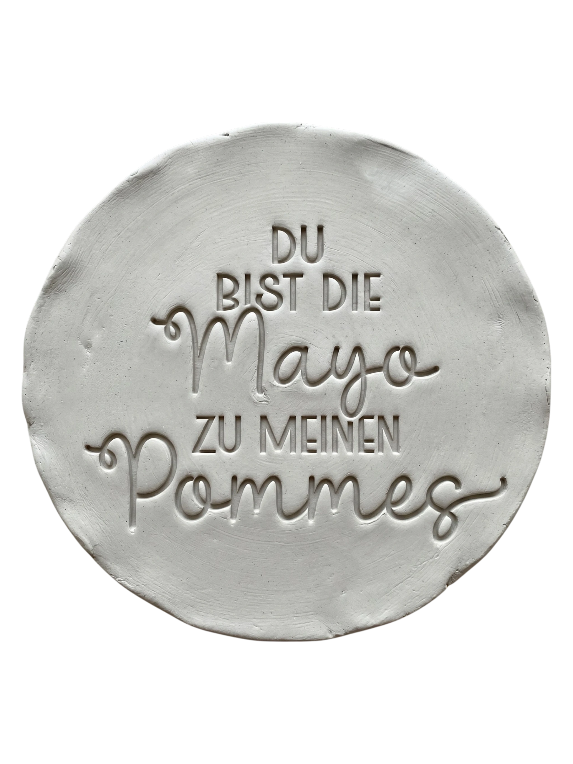 Präziser Stempelabdruck des humorvollen Spruchs 'Du bist die Mayo zu meinen Pommes' in hellem Ton. Detailreiches und sauberes Relief auf einer runden Tonplatte für handgemachte Keramik.