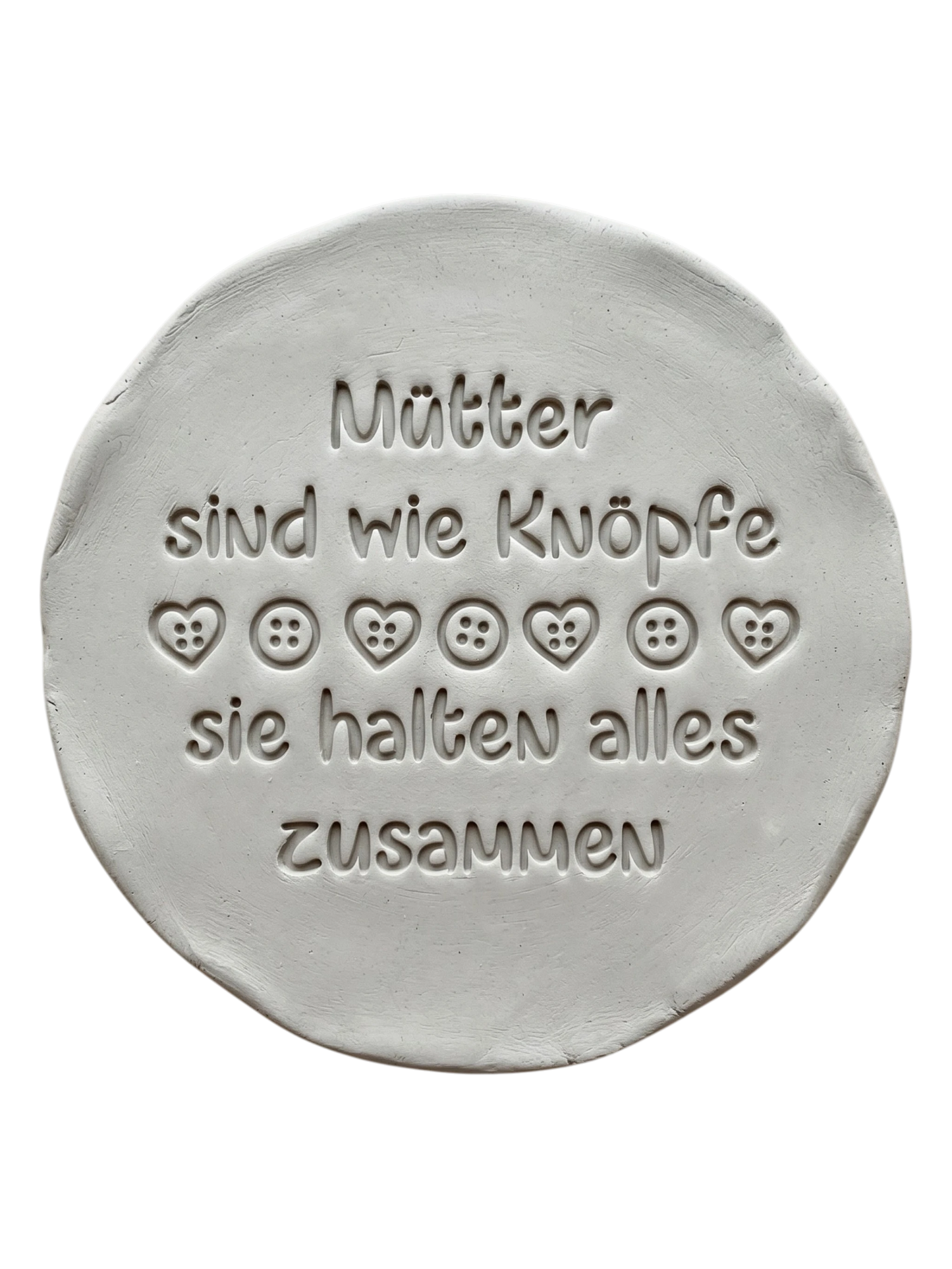 Liebevolle Töpfer-Idee zum Muttertag: Ton-Anhänger mit dem eingestempelten Spruch 'Mütter sind wie Knöpfe, sie halten alles zusammen'. Erstellt mit einem MinseArt Keramikstempel. Präziser Abdruck mit Herz- und Knopf-Details in hellem Ton.