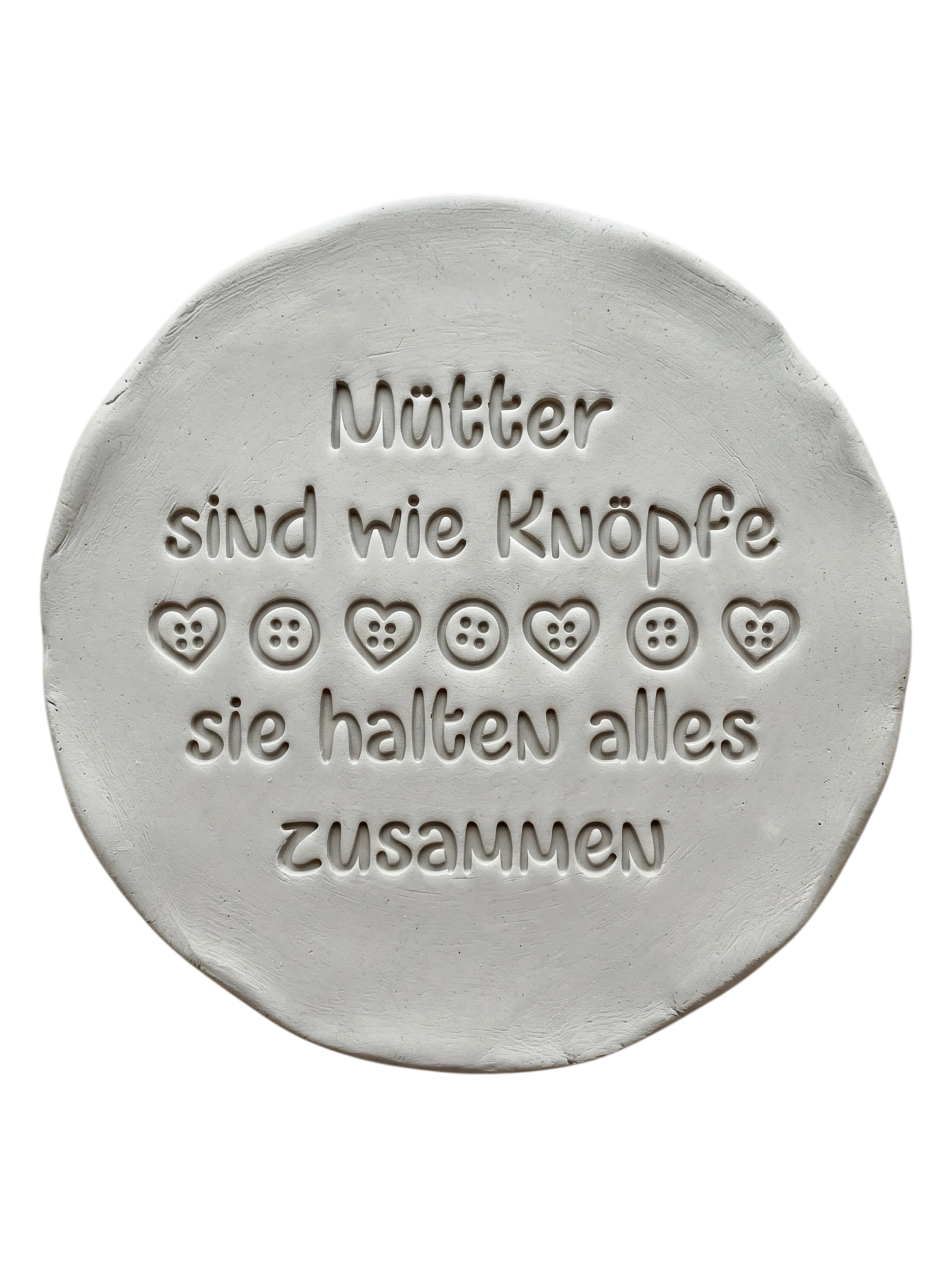 Liebevolle Töpfer-Idee zum Muttertag: Ton-Anhänger mit dem eingestempelten Spruch 'Mütter sind wie Knöpfe, sie halten alles zusammen'. Erstellt mit einem MinseArt Keramikstempel. Präziser Abdruck mit Herz- und Knopf-Details in hellem Ton.