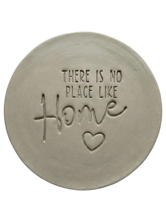 Präziser Stempelabdruck 'There is no place like Home' mit Herz in hellem Ton. Die Kombination aus moderner Serifenschrift und schwungvoller Schreibschrift erzeugt ein sauberes Relief für Töpferprojekte.