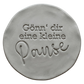 Präziser Stempelabdruck 'Gönn’ dir eine kleine Pause' in hellem Ton. Die Kombination aus Druckschrift und schwungvoller Schreibschrift erzeugt ein sauberes Relief.