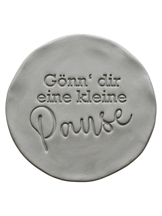 Präziser Stempelabdruck 'Gönn’ dir eine kleine Pause' in hellem Ton. Die Kombination aus Druckschrift und schwungvoller Schreibschrift erzeugt ein sauberes Relief.