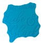 Die Rückseite des türkisfarbenen Keramikstempels zeigt die integrierte Positionierungshilfe. Dieses nützliche Töpferwerkzeug ermöglicht ein perfekt gerades Ausrichten des Schriftzugs auf dem Ton.