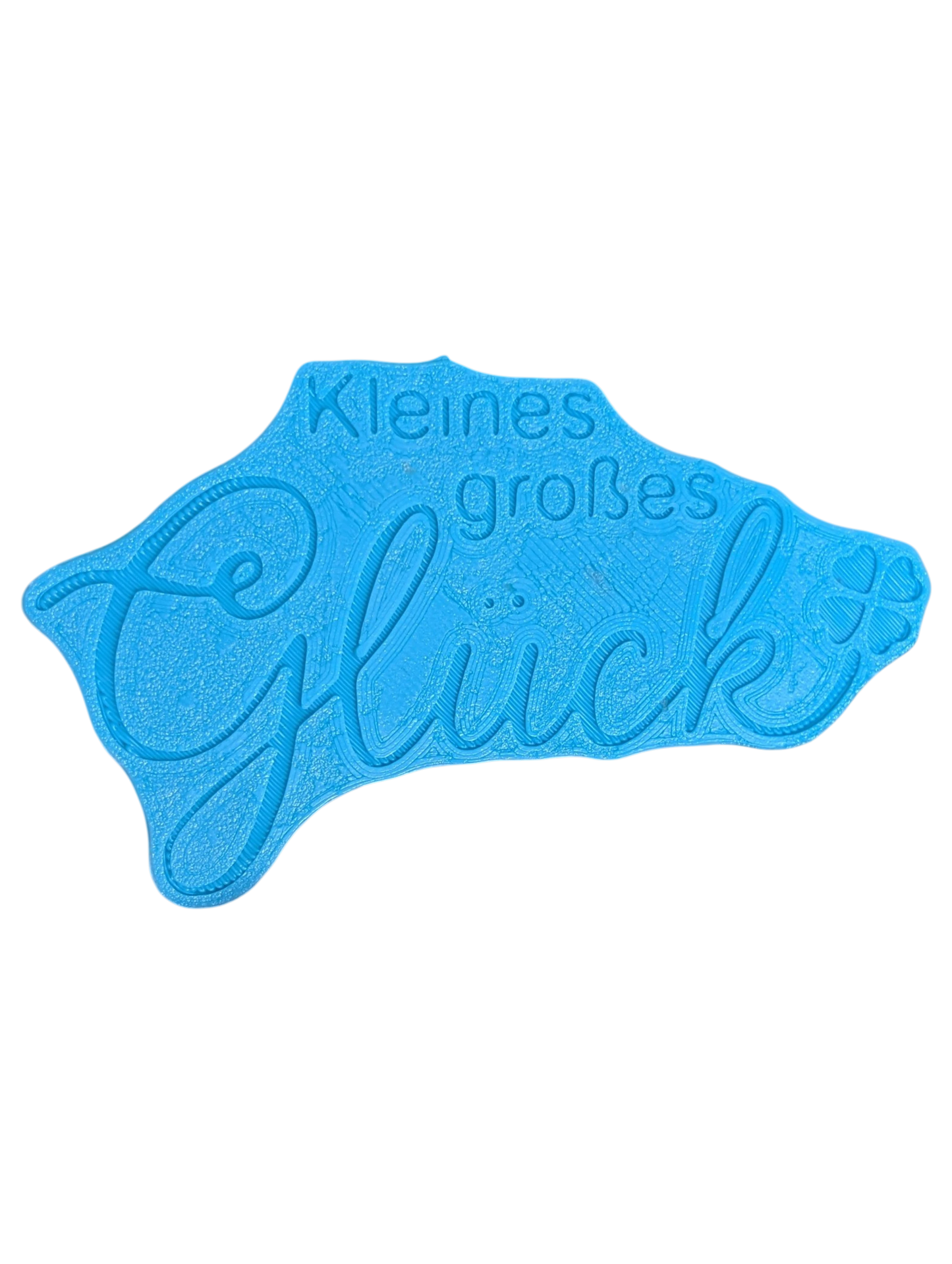 Die Rückseite des hochwertigen Keramikstempels zeigt die praktische Positionierungshilfe. Dieses durchdachte Töpferwerkzeug ermöglicht ein perfekt gerades Ausrichten des Schriftzugs 'Kleines großes Glück' auf dem Ton.