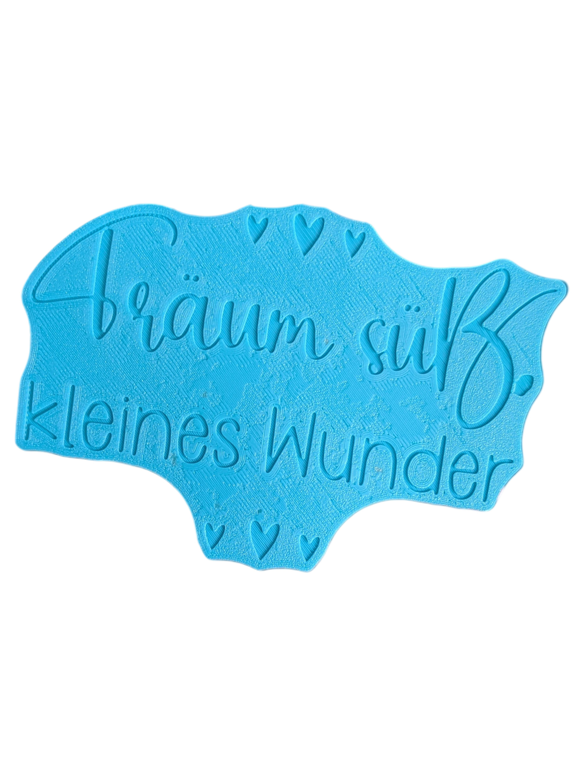 Die Rückseite des türkisfarbenen Keramikstempels zeigt die spiegelverkehrte Positionierungshilfe. Dieses durchdachte Töpferwerkzeug ermöglicht ein perfekt gerades Ausrichten des Schriftzugs auf dem Ton.