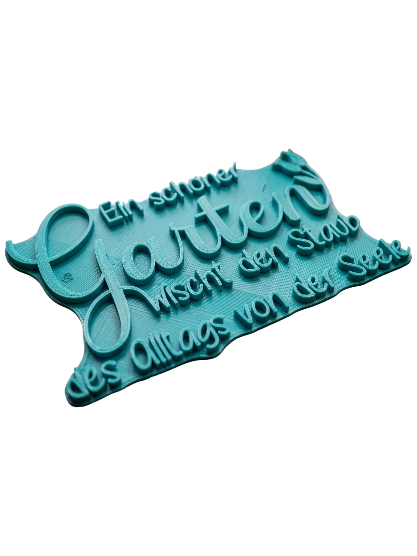 Türkisfarbener Keramikstempel für Ton mit dem Schriftzug 'Ein schöner Garten wischt den Staub des Alltags von der Seele' und einem zarten Blumenmotiv. Hochwertiges Töpferwerkzeug für detailgetreue Prägungen.