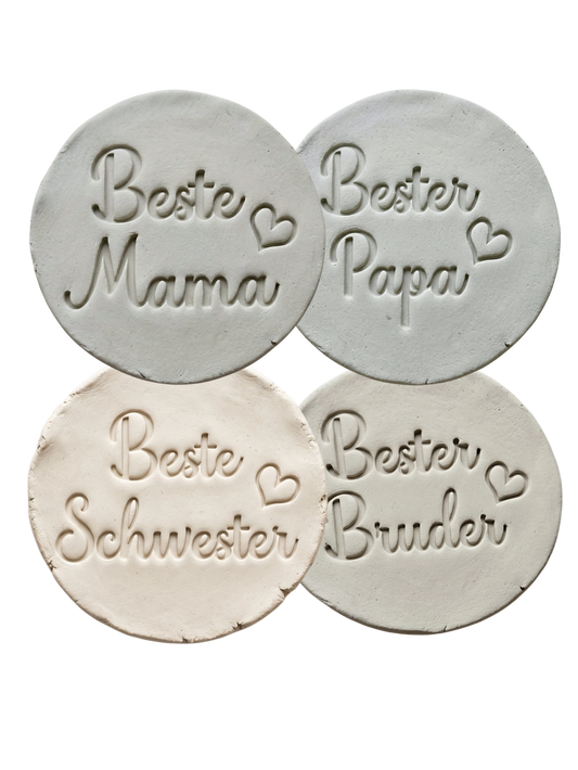 Vier verschiedene Abdrücke im Ton: Beste Mama, Bester Papa, Beste Schwester und Bester Bruder. Die präzisen Schriftzüge mit Herz-Details wurden mit dem MinseArt Spar-Set erstellt. Inspiration für persönliche Geschenke aus Keramik für die ganze Familie.