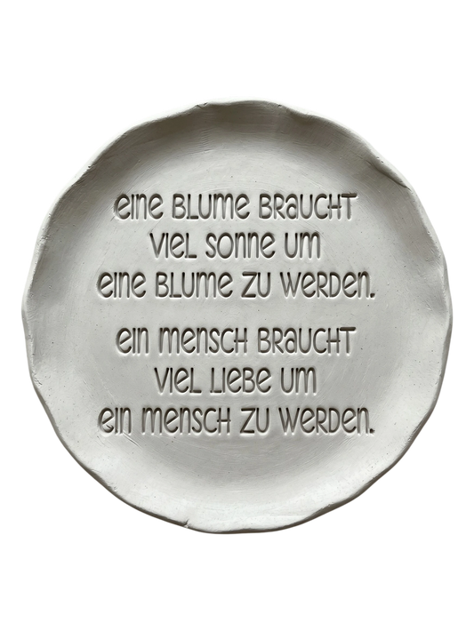 Präziser Abdruck im hellen Ton mit dem Spruch über Blumen, Sonne und Liebe. Kreative Töpfer-Idee für Wandteller, Türschilder oder Geburtsgeschenke.