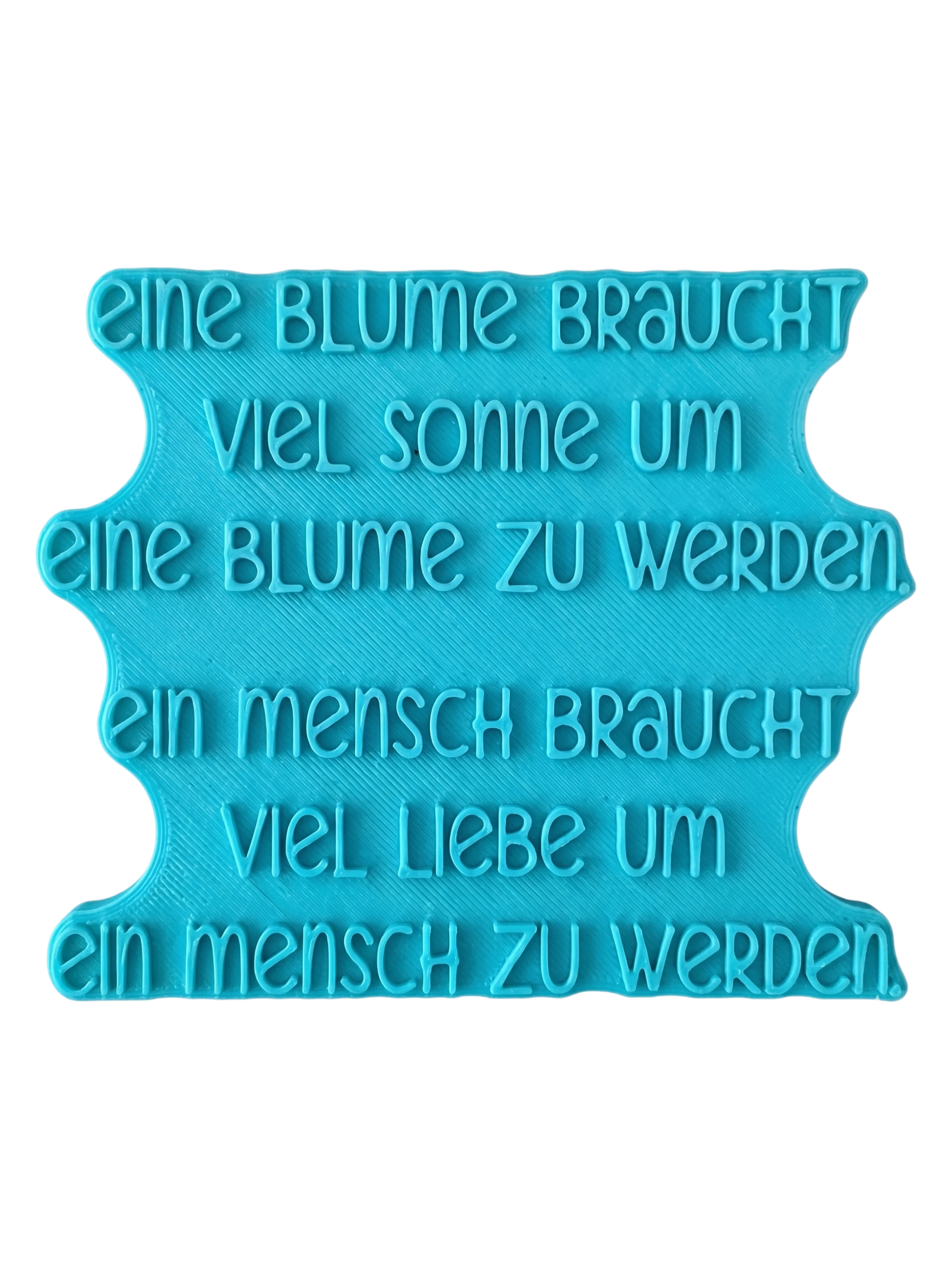 Blaugrüner Textstempel für Ton mit dem Spruch 'Eine Blume braucht viel Sonne...'. Stabiles Werkzeug für saubere, tiefe Prägungen in Keramik.