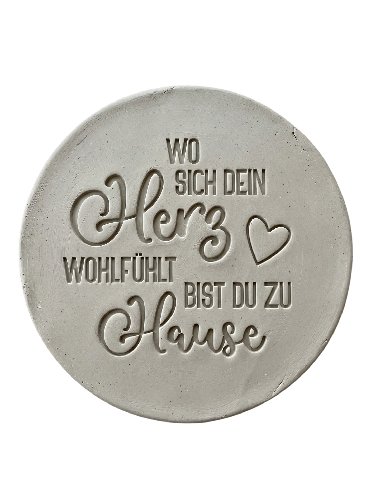 Präziser Abdruck im rohen Ton mit dem Spruch 'Wo sich dein Herz wohlfühlt bist du zu Hause'. Gestaltet mit einem MinseArt Keramikstempel. Detailreiche Töpfer-Idee für Türschilder oder dekorative Wandteller aus Keramik.