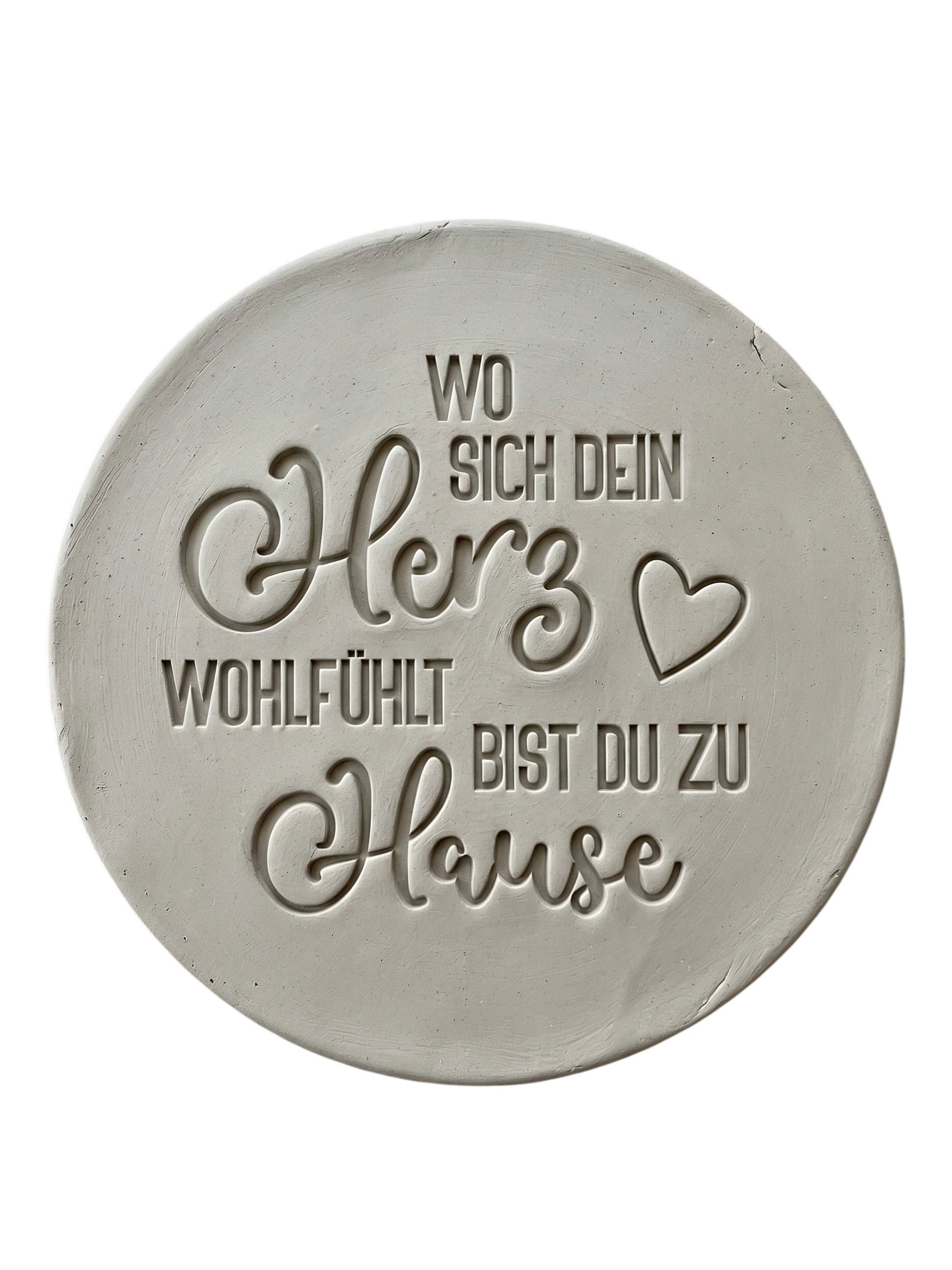 Präziser Abdruck im rohen Ton mit dem Spruch 'Wo sich dein Herz wohlfühlt bist du zu Hause'. Gestaltet mit einem MinseArt Keramikstempel. Detailreiche Töpfer-Idee für Türschilder oder dekorative Wandteller aus Keramik.