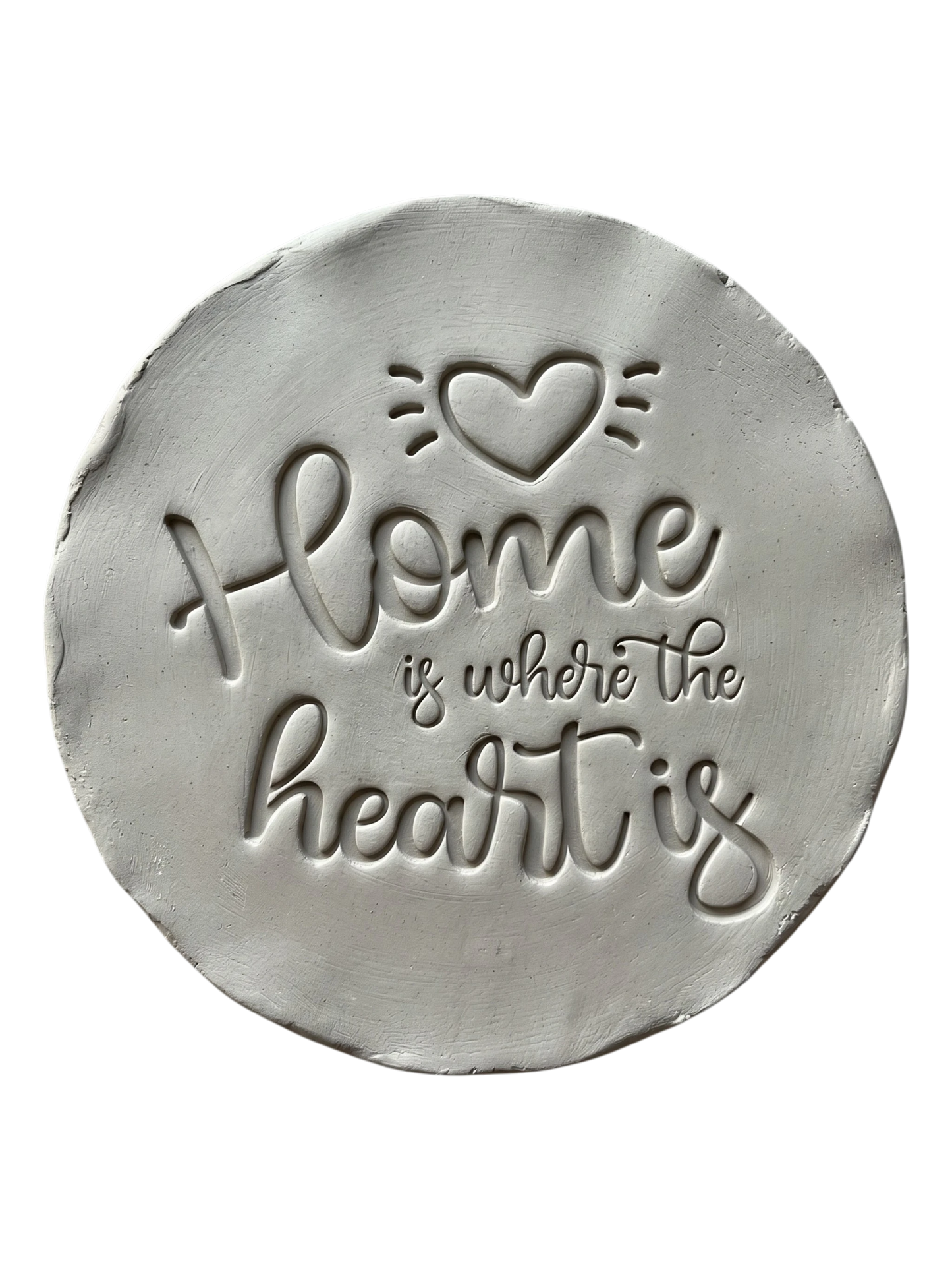 Präziser Abdruck im hellen Ton mit dem englischen Spruch 'Home is where the heart is'. Kreative Töpfer-Idee für Türschilder, Einzugsgeschenke oder dekorative Wandteller.